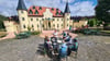 Charlotte Valdiek, Geschäftsführerin des "Märchenparks und Duftgartens" Salzwedel, vor dem Schloss an einem königlichen Tisch mit Figuren.