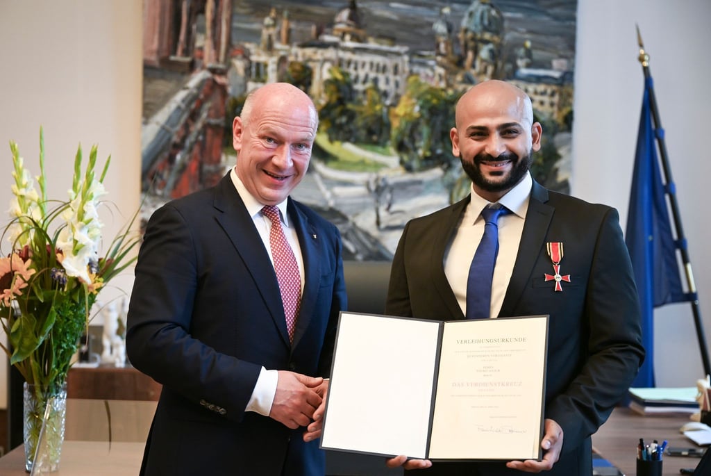 Kai Wegner hat Yousef Ayoub das Bundesverdienstkreuz samt Urkunde überreicht.