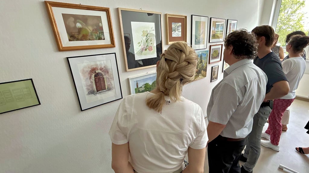 Beim Betrachten der Bilder kommen Mitarbeiter ins Gespräch über Motive und Techniken.