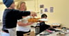 Künstlerin Julia Baum erklärt im Workshop der Sommerschule in Wust, wie Insektenfiguren aus wiederverwertbarem Material gebaut werden.