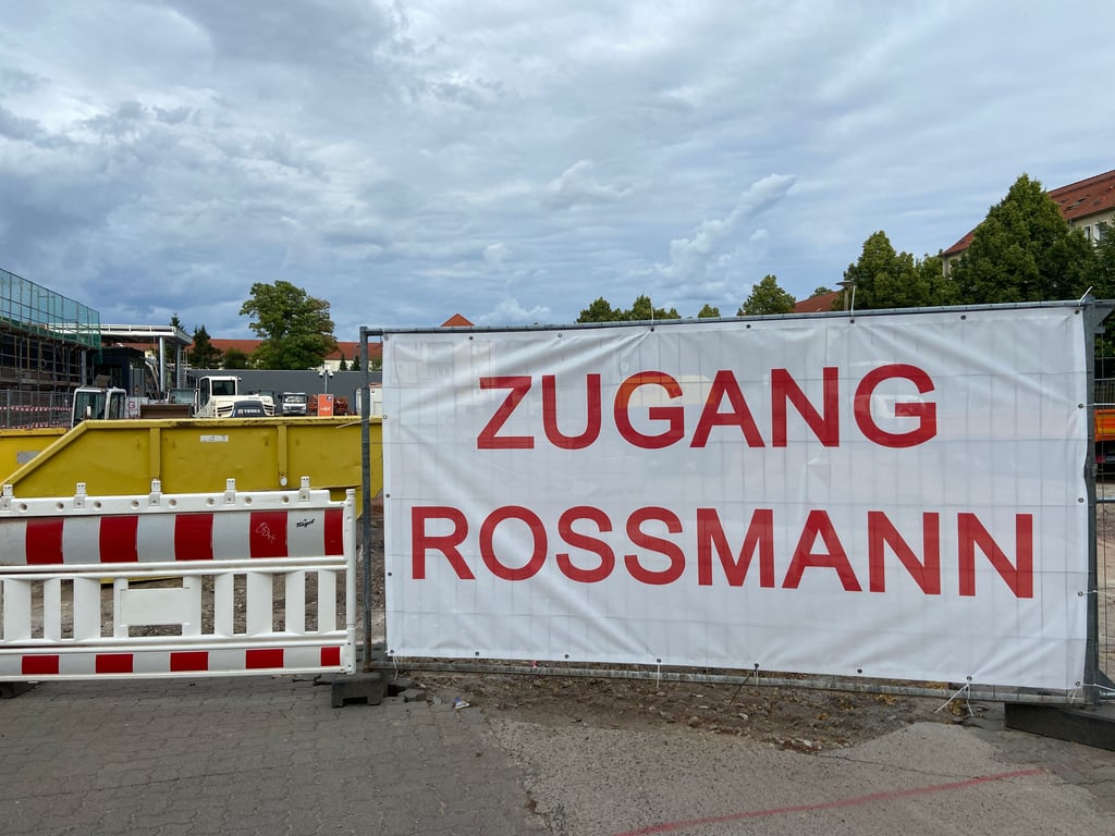 Ein großes Schild weist derzeit den Weg zur Rossmann-Filiale in Magdeburg-Stadtfeld – der eigentliche Eingang liegt hinter Bauzäunen und ist nur schwer zu erkennen.