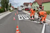 <source><sha1>M95Wi08J630dt6adE6caJhcbs40</sha1><p>Bei strahlendem Sonnenschein wurde am Dienstagvormittag die grundhaft sanierte Kreisstraße 2317 in <a href="https://www.mz.de/lokal/eisleben/die-tollkuhne-liebeserklarung-von-gunther-saken-an-seinen-heimatort-4086687">Seeburg</a> offiziell freigegeben. Kurz vor der Eröffnung brachte die Baufirma noch die Markierung „BUS“ vor den Haltestellen auf der Fahrbahn auf – quasi ein symbolischer letzter Pinselstrich für das Projekt.</p><p>Nach rund acht Monaten Bauzeit ist die Straße, die Seeburg mit Rollsdorf verbindet und im Ort den Namen „Straße der Freundschaft“ trägt, vollständig erneuert. Der Landkreis Mansfeld-Südharz investierte rund eine Million Euro in das Projekt. </p><h2>Bis vor kurzen war die Kreisstraße noch eine Rumpelpiste</h2><p>Ortsbürgermeister Günter Saken (Bürgerliste Süßer See) erinnerte an den desolaten Zustand der Straße vor dem Ausbau: „Die Anwohner berichteten, dass das Geschirr in den Schränken klirrte, wenn Lkw vorbeifuhren.“ Die Fahrbahn bestand aus einer Mischung aus Asphaltstücken und Pflastersteinen – ein Flickenteppich, der den heutigen Anforderungen nicht mehr gerecht wurde. Deshalb sei man sehr froh gewesen, als der Kreis den Ausbau der Straße im vorigen Jahr in den Etat aufnahm, so Saken.</p><p>Auf einer Länge von 500 Metern wurde die Kreisstraße innerorts grundhaft ausgebaut – mit einem Aufbau aus insgesamt 54 Zentimetern Tragschichten, die nun unter dem neuen Asphalt verborgen liegen. Die Baukosten beliefen sich auf 991.000 Euro, getragen vom Landkreis. Landrat André Schröder (CDU) betonte die gute Zusammenarbeit mit der Gemeinde Seegebiet Mansfelder Land, dem Abwasserzweckverband und den Stadtwerken Eisleben: „Es war ein fantastisches Teamwork.“ Seit Beginn seiner Amtszeit im Jahr 2021 seien bereits 14 Millionen Euro in den Ausbau von Kreisstraßen im Landkreis investiert worden – weitere Projekte seien in Planung.</p><h2>Landrat sieht in Seeburg eine Schönheit, die man sonst nur auf Postkarten sieht</h2><p>Schröder lobte die Maßnahme als wichtigen Schritt für die Region: „Seeburg ist einer der schönsten Orte im Landkreis – ein echtes Beispiel für das, was man als ‚Postkartendeutschland‘ bezeichnen kann.“ Gerade für einen touristisch geprägten Ort wie Seeburg sei eine intakte Infrastruktur unerlässlich. Die neue Straße sei nun ein Aushängeschild – nicht nur für Gäste, sondern auch für die Lebensqualität der Einwohner.</p><p>Die Gemeinde Seegebiet Mansfelder Land selbst brachte sich aktiv in das Bauprojekt ein: Bürgermeister Martin Blümel (parteilos) berichtete, dass zusätzlich zu den Mitteln des Landkreises noch einmal 400.000 Euro aus Eigenmitteln der Seegebietsgemeinde – ganz ohne Fördermittel – beispielsweise in den Ausbau von Gehwegen und Parktaschen investiert wurden. </p><h2>Gute Zusammenarbeit mit der Baufirma</h2><p>Blümel lobte die Zusammenarbeit mit der ausführenden Firma Kutter HTS, die auf alle Wünsche eingegangen sei, und dankte den Anwohnerinnen und Anwohnern für ihre Geduld während der Bauzeit. Die zeigten sich zufrieden mit dem Ergebnis – und lobten die Bauleute von Kutter HTS als „sehr höflich“ und „zuvorkommend“. Man sei auf alle Bitten eingegangen. Dennoch überwiegt nun die Erleichterung, dass die Bauarbeiten abgeschlossen sind und die Zeit der Umleitungen vorbei ist.</p><p>Blümel nutzte die Gelegenheit, um auf weitere Projekte in Seeburg hinzuweisen: So soll der Parkplatz am Nordufer des Süßen Sees erneuert werden – ein weiterer Baustein zur touristischen Aufwertung des Ortes. Auch das Strukturwandelprojekt in Seeburg nehme mehr und mehr Gestalt an: Der Wirtschaftshof sei inzwischen gekauft.</p><h2>Warum es jetzt Arbeit für die Polizei gibt</h2><p>Ein kleiner Wermutstropfen bleibt: Die neue, glatte Fahrbahn verleitet offenbar einige Verkehrsteilnehmer zum Rasen. Die Regionalbereichsbeamten des Seegebiets werden in nächster Zeit ein wachsames Auge auf die Einhaltung der Geschwindigkeit haben.</p>