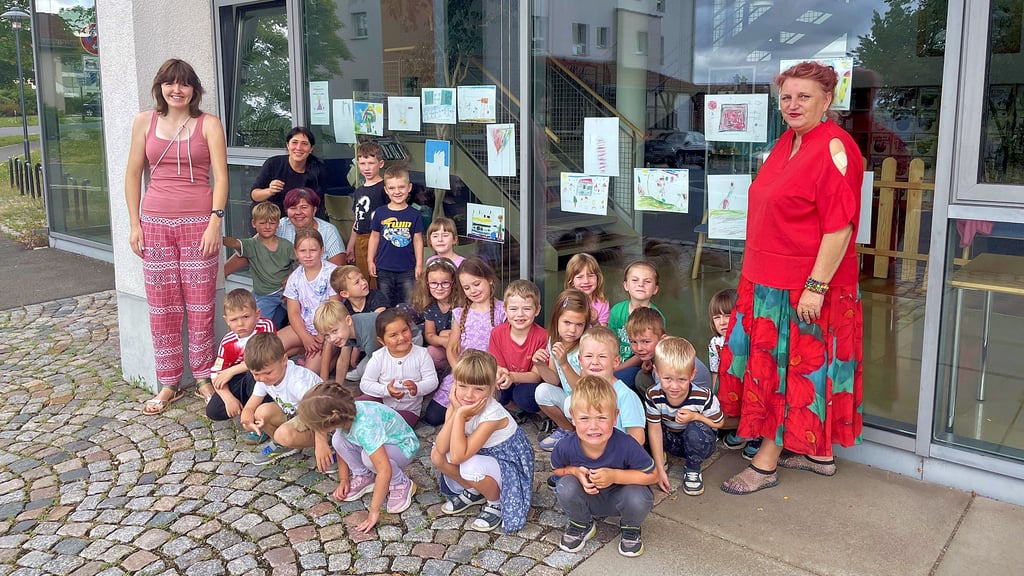 Museums-Mitarbeiterin Ilonka Struve (r.) mit den Kindern der Kita „Spatzennest“, Bibliotheksleiterin Jana Herzig (hinten mit schwarzem Oberteil) und den Kita-Mitarbeiterinnen Nadine Reichelt (vor Jana Herzig sitzend) und Christin Spalek (l.)
