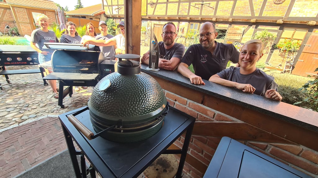 Mitglieder von „Gogrillaz“ Colbitz (v. l.) Janine Vötzsch, Vicky Kretschel, Susi Maass, Steffi Hoppe, Michi Senst, Basti Maass, Tim Hoppe und Nadine Senst. Im „Smoker“ liegt eine Rinderbrust, die über mehrere Stunden hinweg gegrillt wird. Vor Basti Maass steht der Vize-Weltmeister-Pokal.