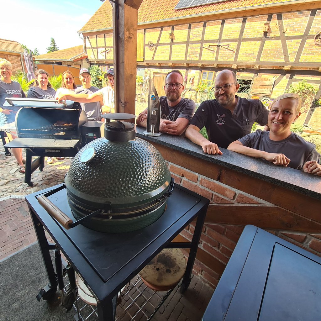 Mitglieder von „Gogrillaz“ Colbitz (v. l.) Janine Vötzsch, Vicky Kretschel, Susi Maass, Steffi Hoppe, Michi Senst, Basti Maass, Tim Hoppe und Nadine Senst. Im „Smoker“ liegt eine Rinderbrust, die über mehrere Stunden hinweg gegrillt wird. Vor Basti Maass steht der Vize-Weltmeister-Pokal.