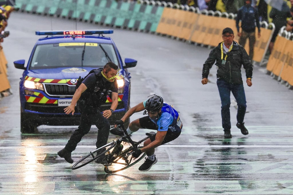 Ein Mann fährt bei der Tour de France unerlaubt über die Strecke.