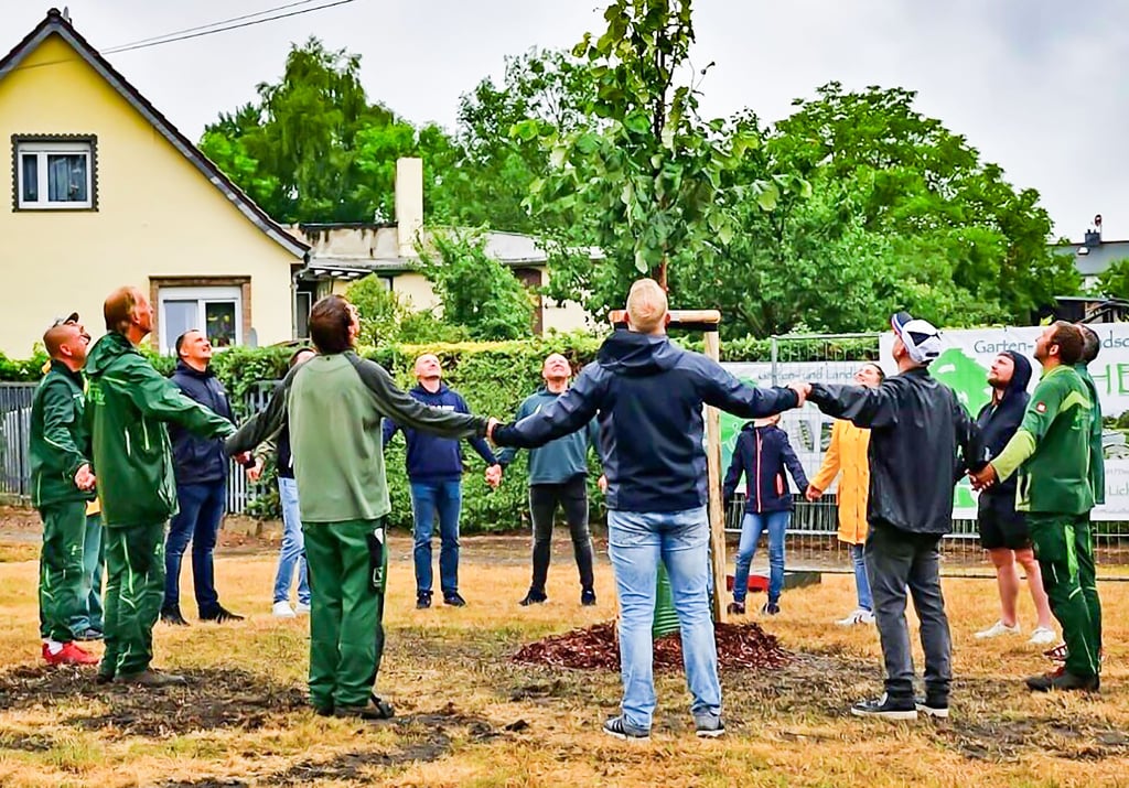 Freunde von Markus Graul bilden einen Kreis um den Baum für den Verstorbenen, der in der Kochstedter Ortsmitte steht.