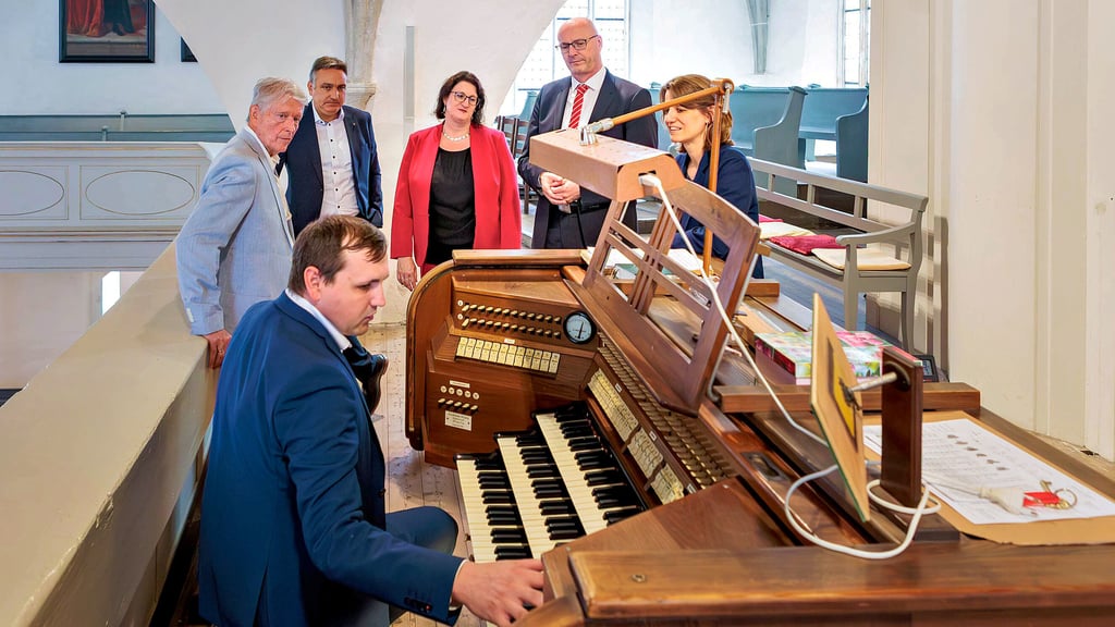 Norman Neitz, stellvertretender Vorsitzender des Fördervereins, zeigt den Gästen der Ostdeutschen Sparkassenstiftung und der Sparkasse Burgenlandkreis die Mängel der alten Rühlmannorgel in der Michaeliskirche.