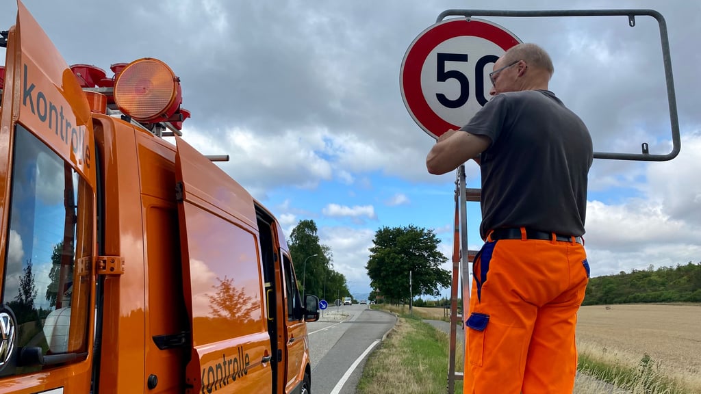 Ein Mitarbeiter der Landesstraßenbaubehörde bringt am Ortseigang Wernigerodes aus Richtung Benzingerode ein provsorisches Tempo-50-Schild an: Das Ortsschild wurde gestohlen.