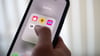 Eine Frau hält ein Smartphone, auf dem Dating-Apps angezeigt werden. (Symbolbild)