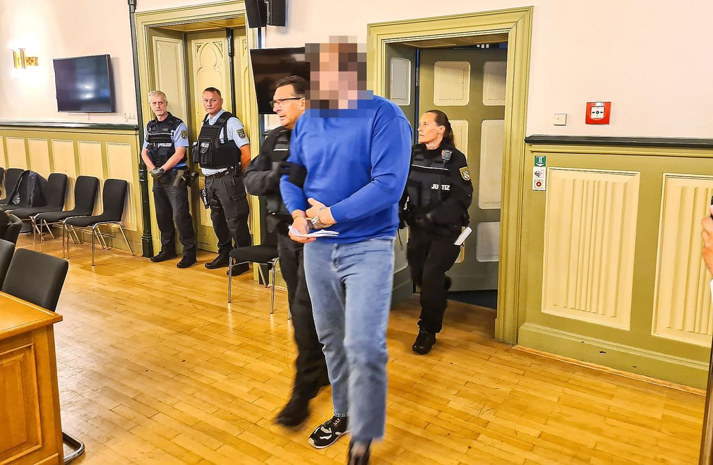 Der Angeklagte Dominik S. wird in Handschellen in den Großen Saal des Landgerichts Stendal geführt