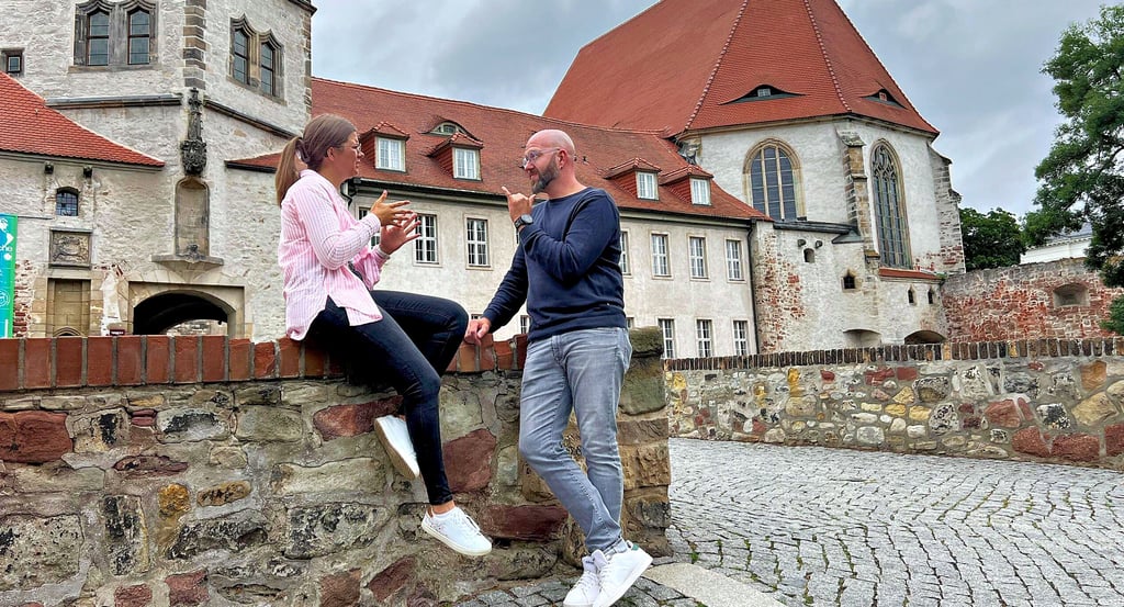 Julia Edler und Henry Niekrawietz unterhalten sich in deutscher Gebärdensprache. An der Moritzburg geben sie Architekturführungen für taube Menschen.