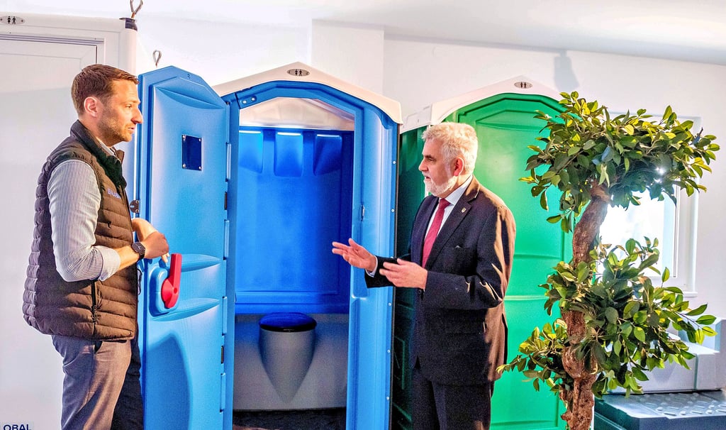 Geschäftführer Jorgo Meyhöfer (l.) erklärt dem Minister, dass etwa 15.000 solcher Miettoiletten jährlich in Coswig produziert werden.