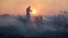 Ein Feuerwehrmann versucht, die Flammen eines Waldbrandes im nordwestlichen Vorort Kryoneri bei Athen zu löschen.