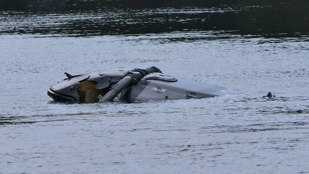 Ein Hubschrauber treibt in der Nähe von Grimma in Sachsen in einem Fluss.