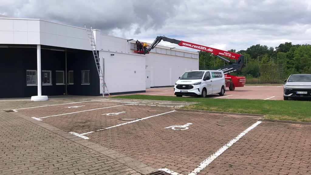 Auf dem Parkplatz sind bereits Stellflächen markiert, am Gebäude des neuen Tedox-Marktes in Quedlinburg wird die Außenwerbung angebracht.
