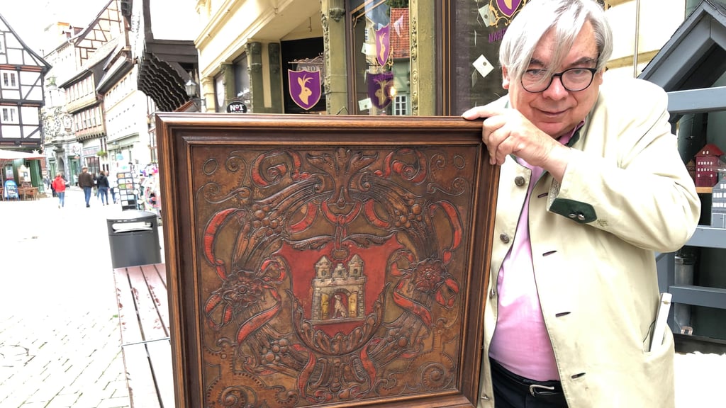 Hubert Kampik zeigt das in Leder geschnittene Wappen, eine Darstellung des historischen Wappens von Quedlinburg.
