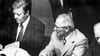 Der deutsche Bundeskanzler Helmut Schmidt (links)  beim Unterzeichnen der KSZE-Schlussakte am 1. August 1975  in Helsinki (Finnland), neben ihm wartet DDR-Staatssekretär Erich Honecker darauf, seine  Unterschrift zu leisten. 