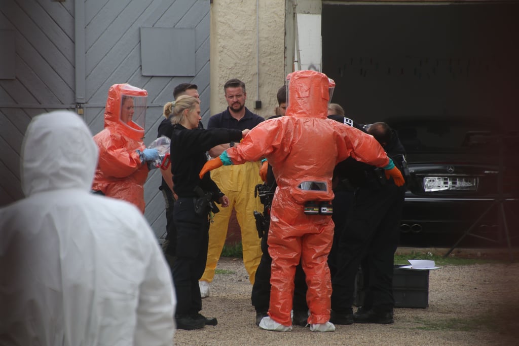 Spezialkräfte in Schutzkleidung bei der Durchsuchung der garagen am Donnerstag in Trotha