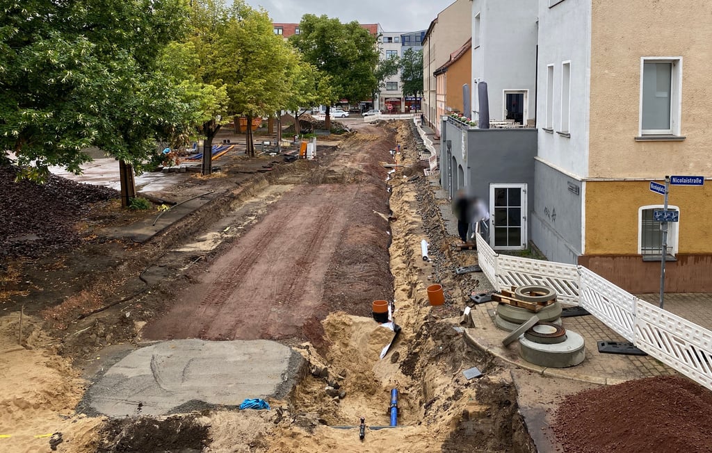 Zwei Passanten klettern über eine Absperrung an der Großbaustelle am Nicolaiplatz. Kein Einzelfall, und die Anwohner sind genervt von der Situation vor Ort.