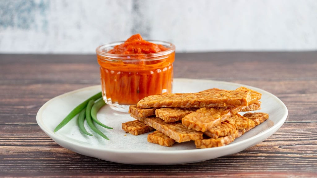 Durch Edelschimmel wachsen Sojabohnen zusammen und werden als Tempeh schnittfest. Es schmeckt würzig, lässt sich geschnitten knusprig braten oder frittieren und wie Chips essen.