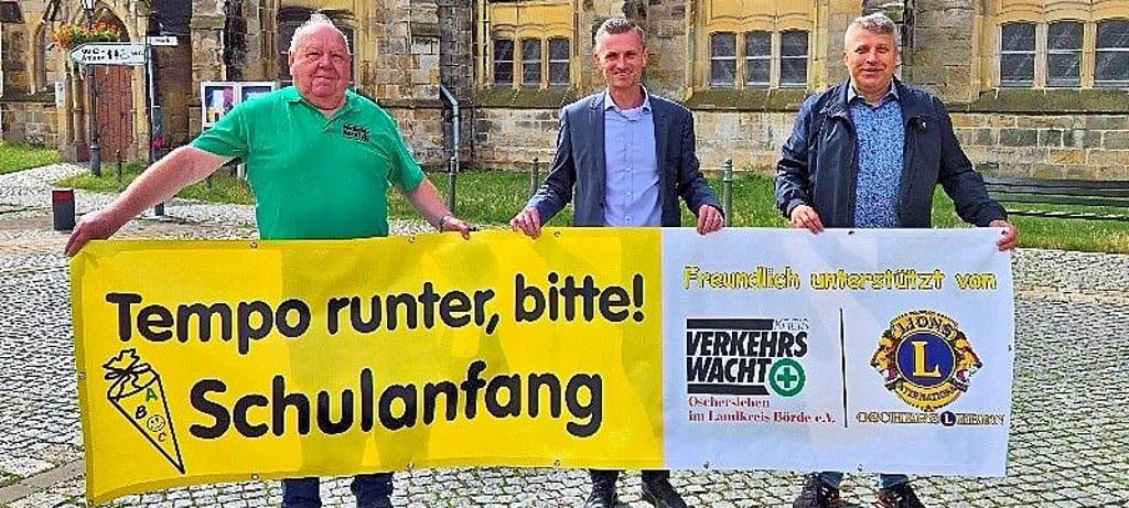 Der Vorsitzende der Kreisverkehrswacht Oschersleben, Klaus Glandien, sowie Oscherslebens Bürgermeister Benjamin Kanngießer und Norbert Lindenblatt, Vizepräsident des Lions-Club Oschersleben (v.l.n.r.), präsentieren Banner mit Appell an Autofahrer.
