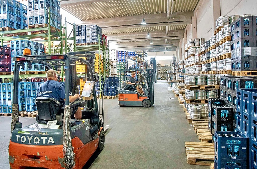 Gabelstaplerfahrer ordern in der großen Lagerhalle Waren für die Kunden.