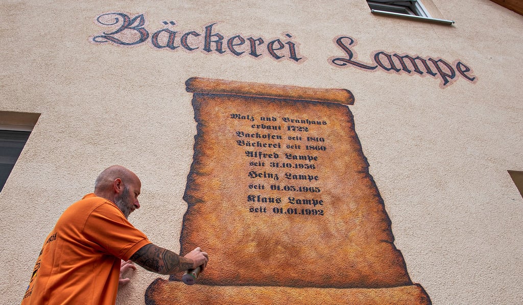 Steffen Blankenburg legt an der Fassade der Bäckerei Lampe in Gleina letzte Hand an.