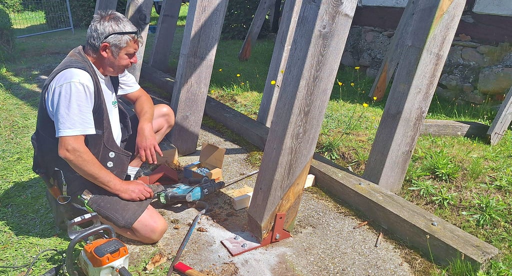 Andreas Bösche montierte die sogenannten Sparrenfußplatten aus Eisen unter die insgesamt zwölf Holzbalken.