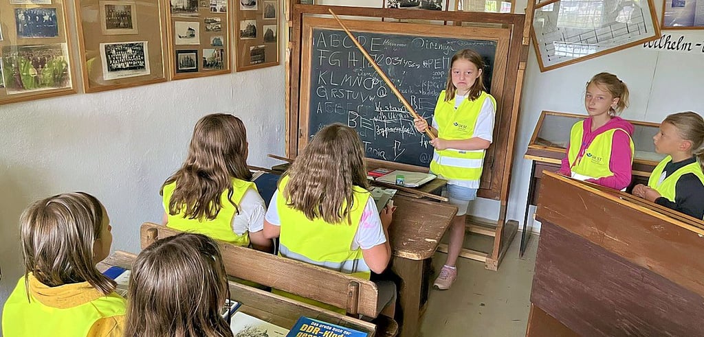 Im Schulmuseum von Tangerhütte zeigt Anna mit Rohrstock und Schiefertafel, wie streng manch ein Lehrer früher war.
