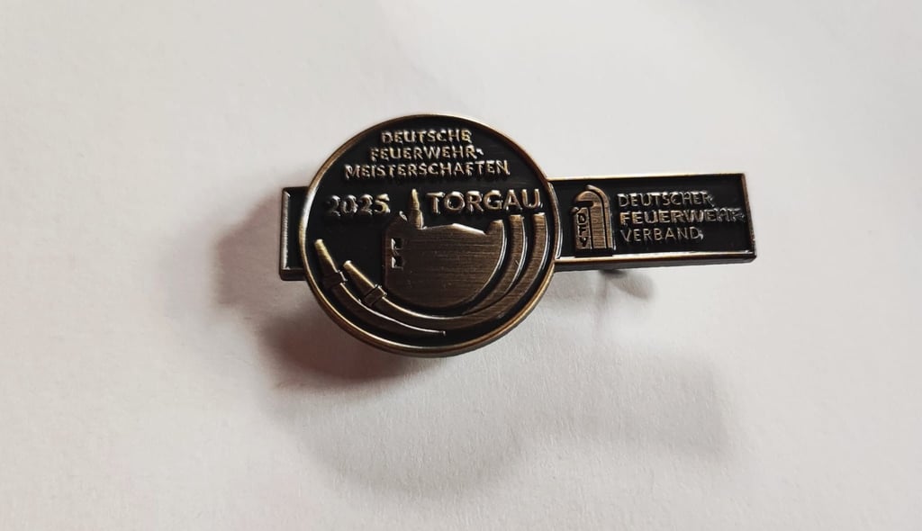Jeder Teilnehmer der Deutschen Meisterschaft im Feuerwehrsport in Torgau 2025 erhielt bei der zweistündigen Siegerehrung am Sonnabend eine Anstecknadel für die Feuerwehruniform.