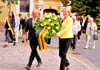 Astrid Hage-Hamatschek und Kersten Henze tragen am Sonntag nach dem ökumenischen Gottesdienst in der Sankt-Nikolai-Kirche in Jessen den Kranz zum Denkmal auf dem Markt.