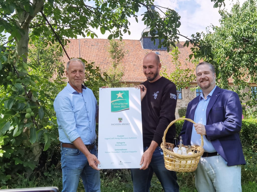 Stephan Koppelin aus Hüttenrode (Mitte) hat mit seinem SagenCraft Honig-Marzipan-Aufstrich einen Kulinarischen Stern abgeräumt. Dafür gab es außerdem ein extra großes Hofschild von Wolfgang Zahn (links) von der AgrarMakrketing-Gesellschaft. Der Honig stammt unter anderem von Bienen, die am Kloster Michaelstein ihr Domizil haben. Die Produkte gibt es auch im Klostershop. Ganz zur Freude von Museumschef Simon Sosnitza (rechts).