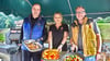 Ines und Stephan Holtorf (rechts) präsentieren zusammen mit Küchenchef Kay Zimmermann das sommerliche Grillbüfett im malerischen Biergarten des „Alten Speichers“ in Altenhausene.