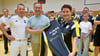 Die Darts-Abteilungsleiterin der Allemannia aus Jessen Ulrike Plass, Sponsor Ronny Schrottke Allemannia-Geschäftsführer Andreas Schrottke (vorn, v.r.) präsentieren stolz die neue Kleidung der Darts-Sportler.