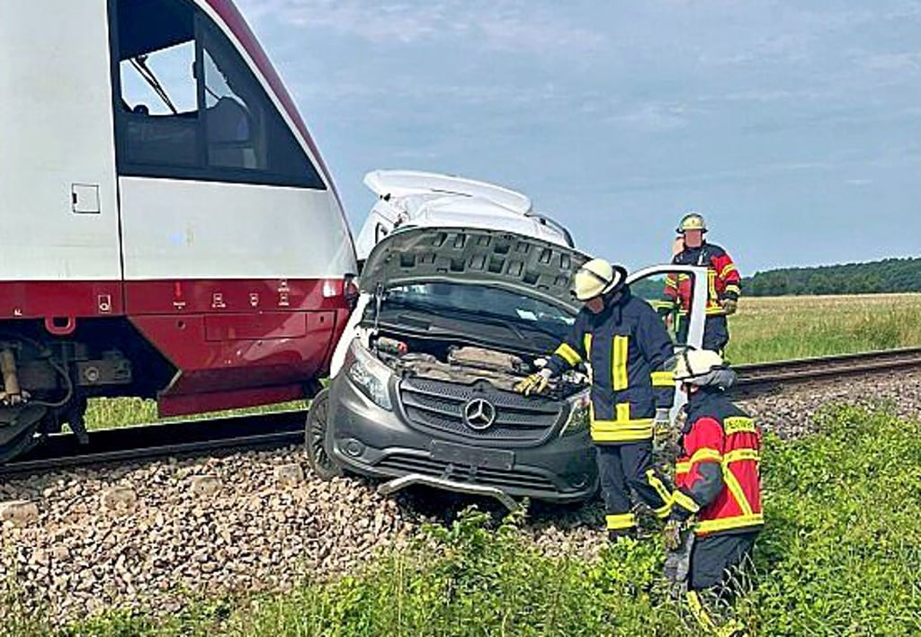 Feuerwehrleute bergen den verunfallten Transporter am Bahnhübergang in Miltern.