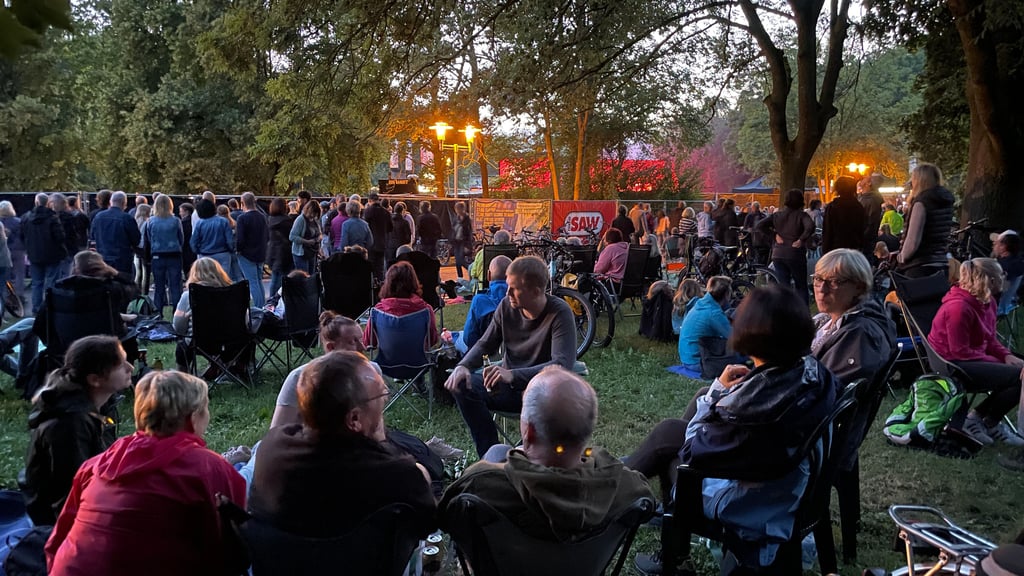 Genießen auch ohne Ticket das Konzert von Bryan Adams auf der Peißnitz: Tausende Zaungäste erleben Livemusik entspannt im Sitzen.