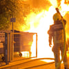 Ein Feuerwehrmann löscht die Flammen, die sich in der Nacht in Magdeburg Stadtfeld-Ost von einer Mülltonne auf mehrere Container ausgebreitet hatten. 