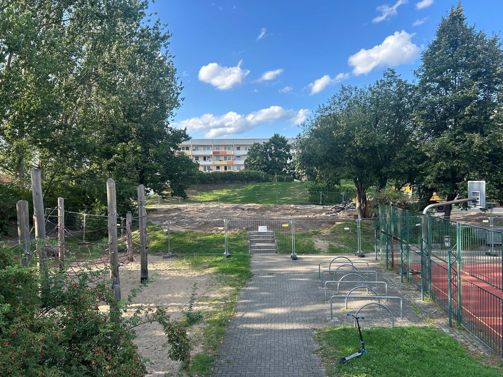 Am Olvenstedter Scheid gibt es verschiedene Möglichkeiten für Kinder und Jugendliche: Links auf dem Bild eine Spielfläche, rechts ein Platz für Ballsportarten und hinten wird gerade der Skatepark abgerissen.