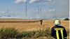 Feuerwehrleute und Landwirte im Einsatz: Gemeinsam versuchen sie, die Flammen auf dem brennenden Acker zu stoppen.