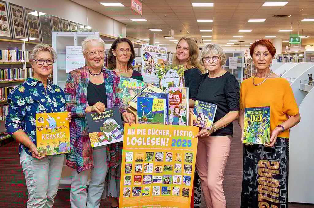 Leiterin Sabine Matzner (hinten, l.) und Mitarbeiterin Antje Key zeigen mit den Lesepatinnen Ulla Flögel (vorn, v.l.), Dorothee Siebert, Regina Kiehn und Maria Kitzmann einige der schönsten Bilderbücher, ausgewählt von Kita-Kindern.