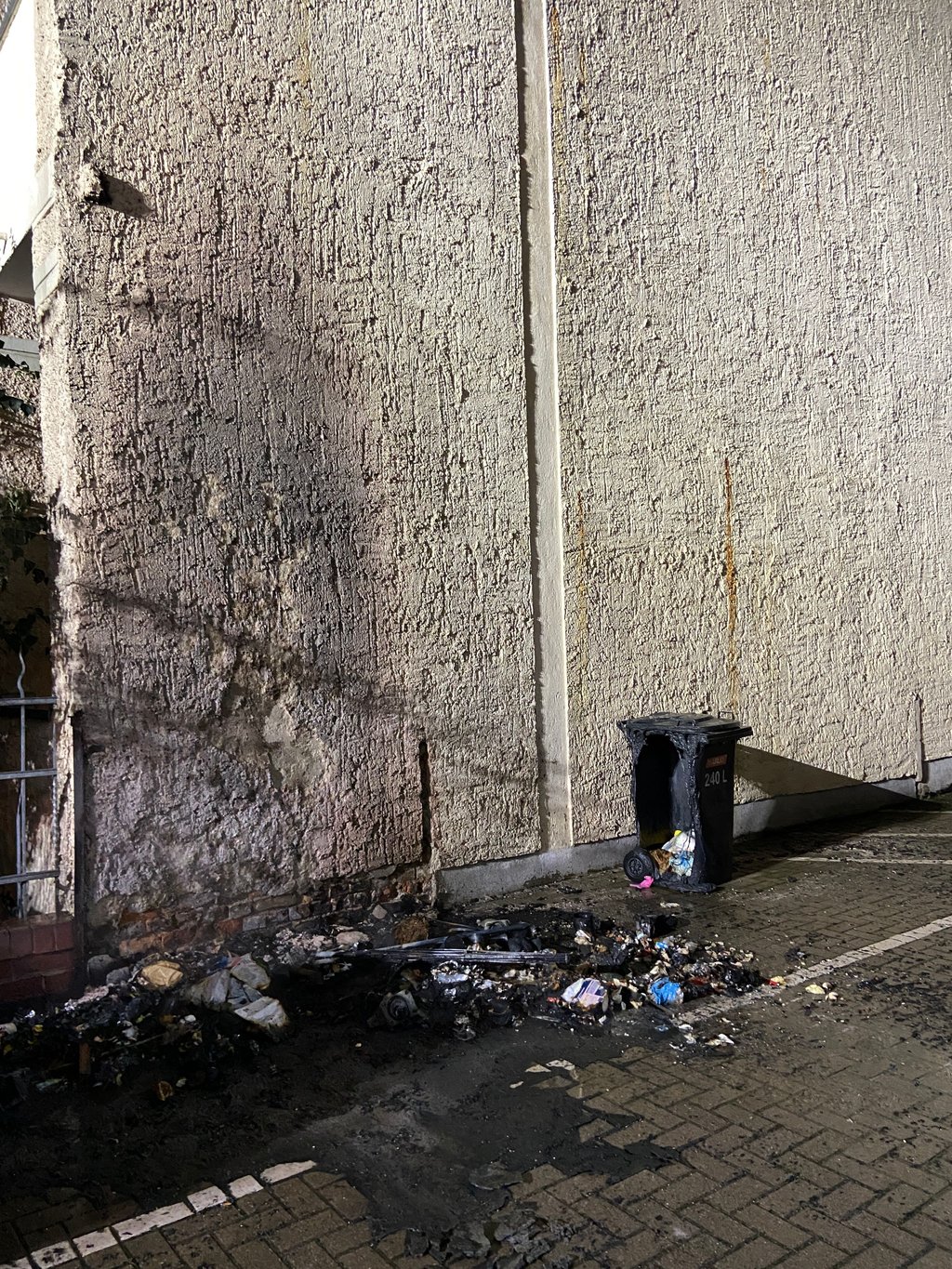 Verbrannte Überreste: Die geschmolzenen Müllcontainer in Magdeburg Stadtfeld-Ost zeugen von dem nächtlichen Brand, der sich zwischen zwei Wohnblöcken ereignete.