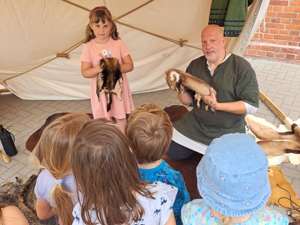 Mittelalter-Fan Martin Lindig zeigt den Kindern des Horts in Magdeburg verschiedene Tierfelle.