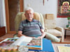 Karl Kuhnke sitzt im Wohnzimmer der Wohnung, in der er seit 66 Jahren lebt. Da, wo im Hintergrund ein Sessel steht, befand sich früher ein Kachelofen.