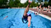 Ein Mann springt im Sommerbad Kreuzberg ins Becken.