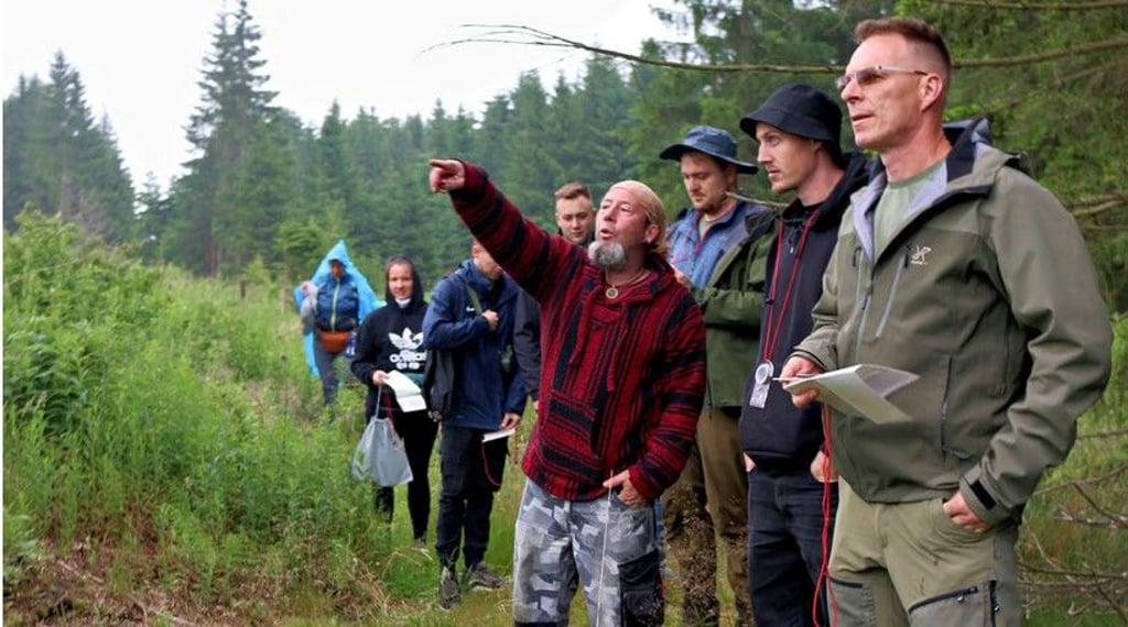 Survival-Experte René Golz (Mitte) zeigt den Teilnehmern seines Camps, wie sie sich orientieren können.