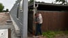Der Magdeburger Olaf Kellner stellt provisorisch einen Bauzaun in die Lücke zwischen Sichtschutz und Carport, damit sein Hund nicht auf die Straße läuft.