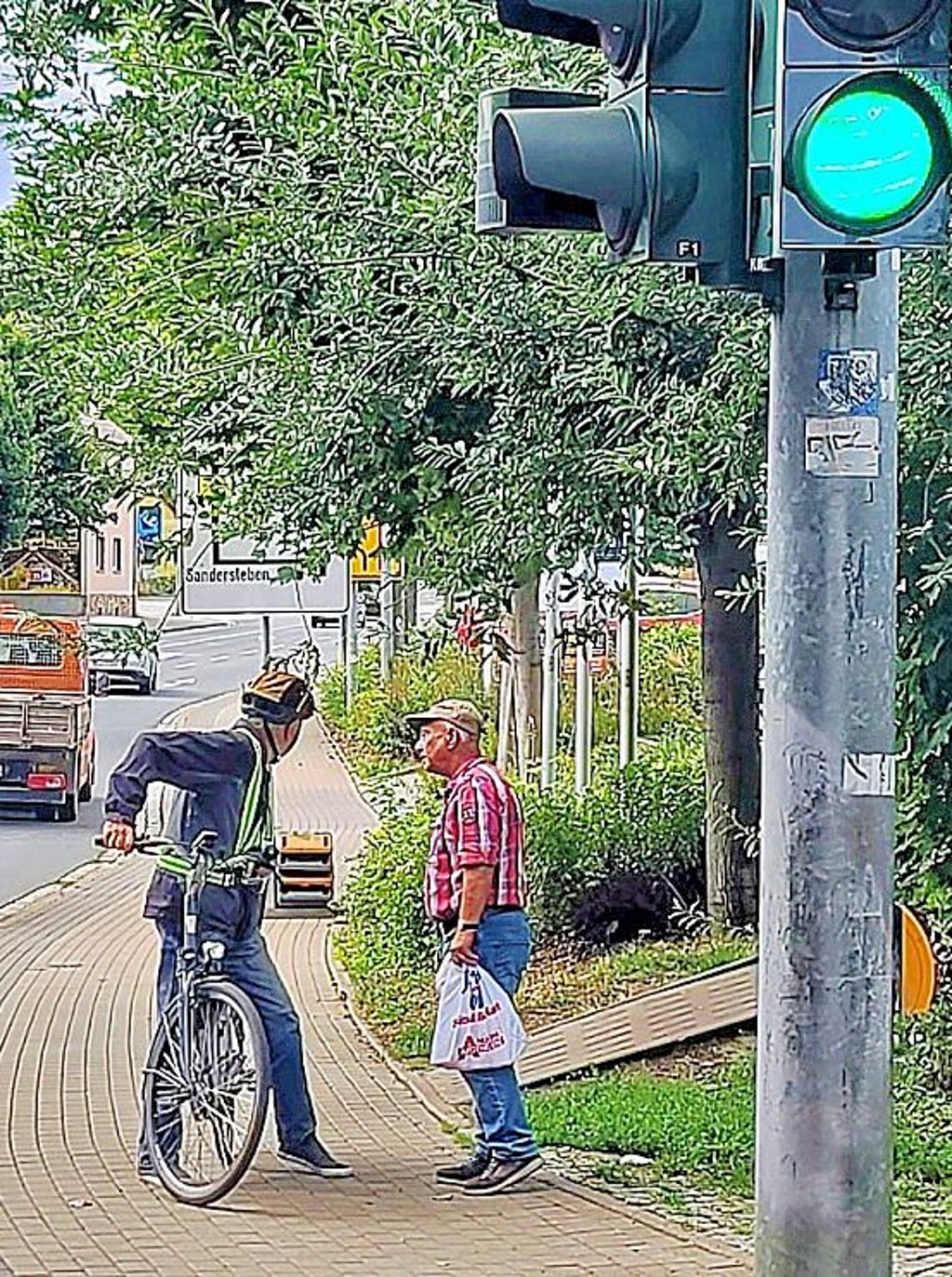 Bäume verdecken das Schild mit der Verkehrsführung.