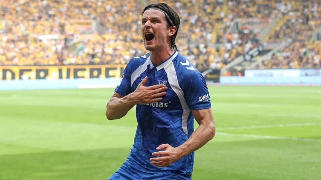 Jean Hugonet hämmert mit der Hand auf das Wappen vom 1. FC Magdeburg.