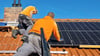 Mitarbeiter der Magdeburger Firma "eab solar" installieren eine Photovoltaik-Anlage auf einem Dach.  Der Sonnenstrom ist auch Dank einer garantierten Einspeisevergütung attraktiv.